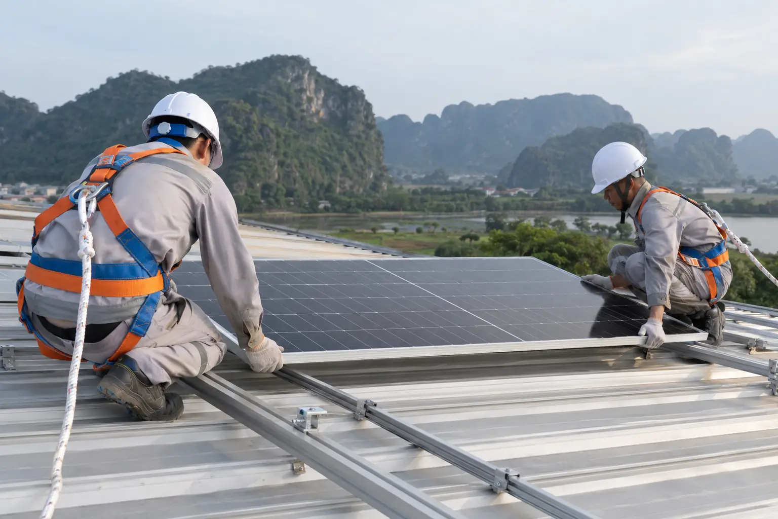 Kỹ thuật viên đeo dây an toàn lắp tấm pin trên mái tôn